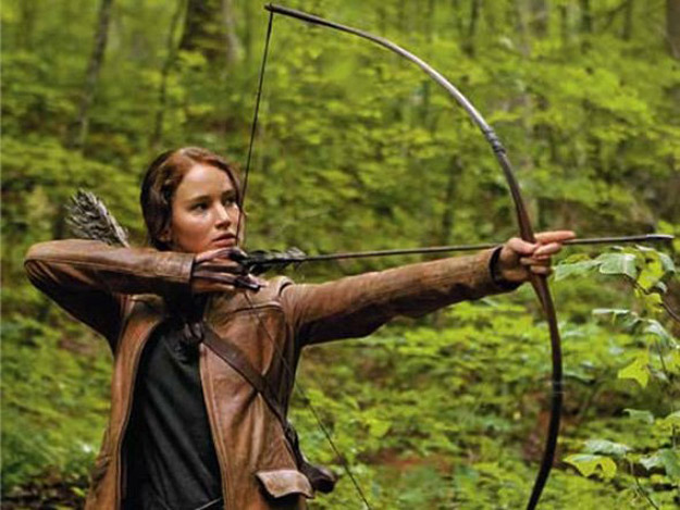 Jennifer Lawrence mostrando suas habilidades com o arco e fecha em Jogos Vorazes.